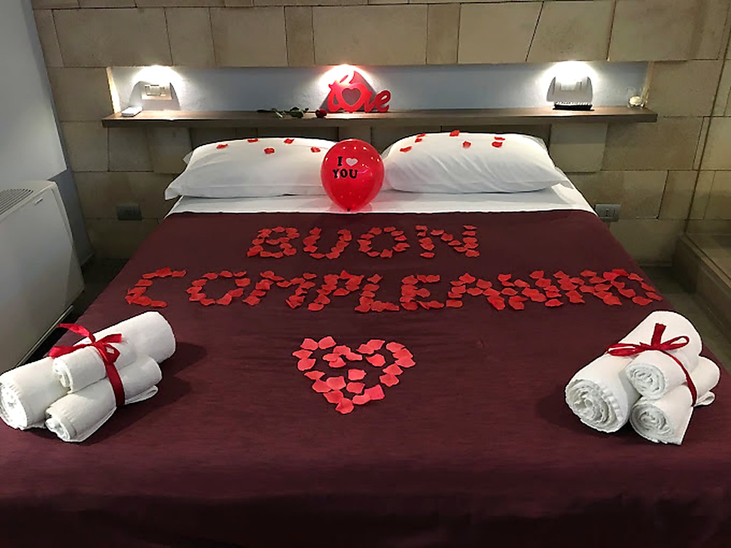 Letto decorato con petali di rosa per il Romantic Package